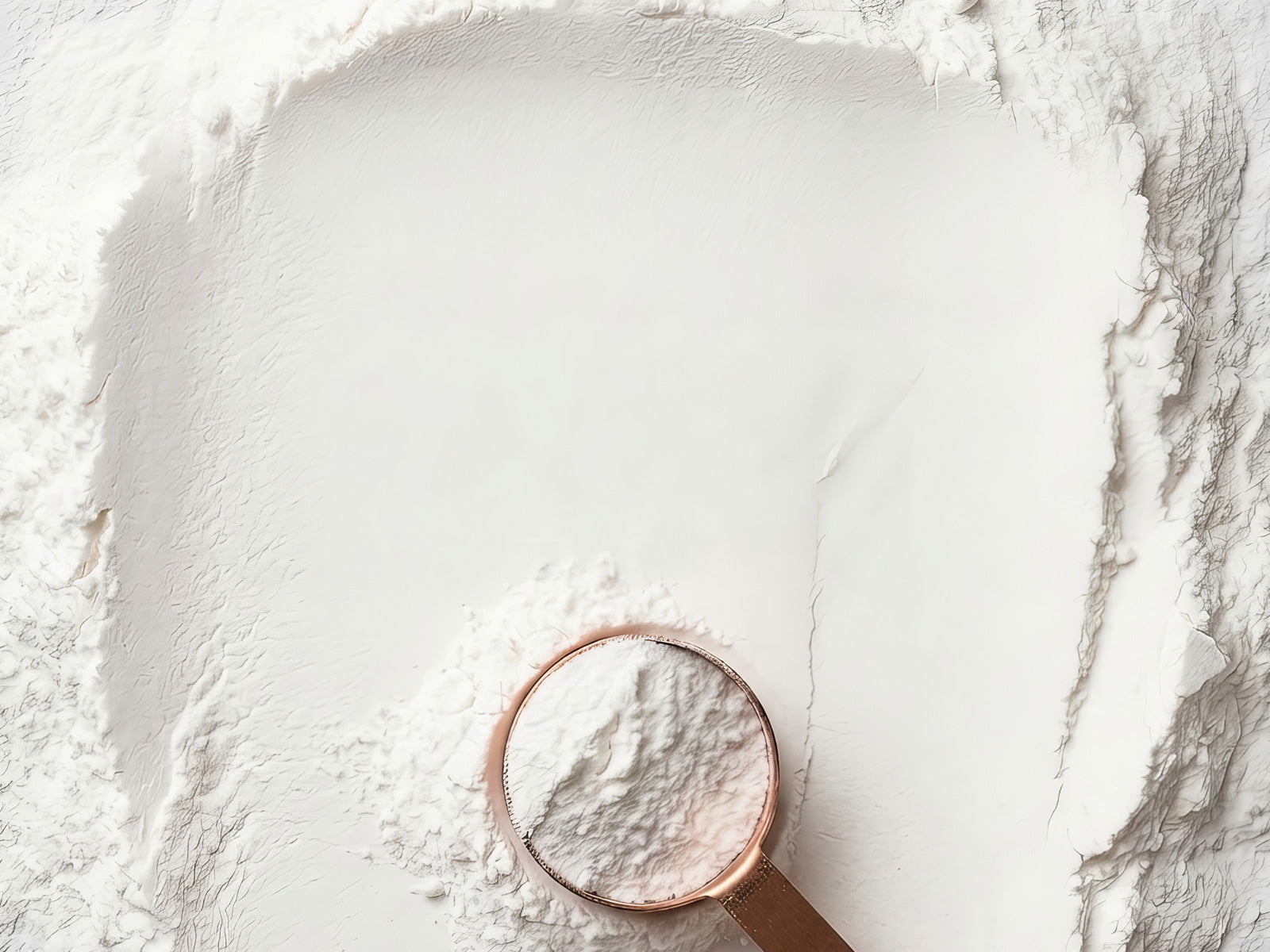 Creatine powder with a copper measuring scoop